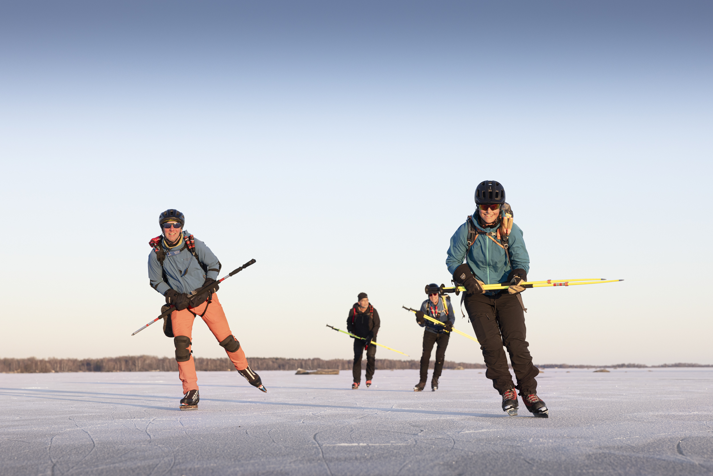 Fyra personer som åker långfärdsskridskor på sjön Hjälmaren i Örebro län